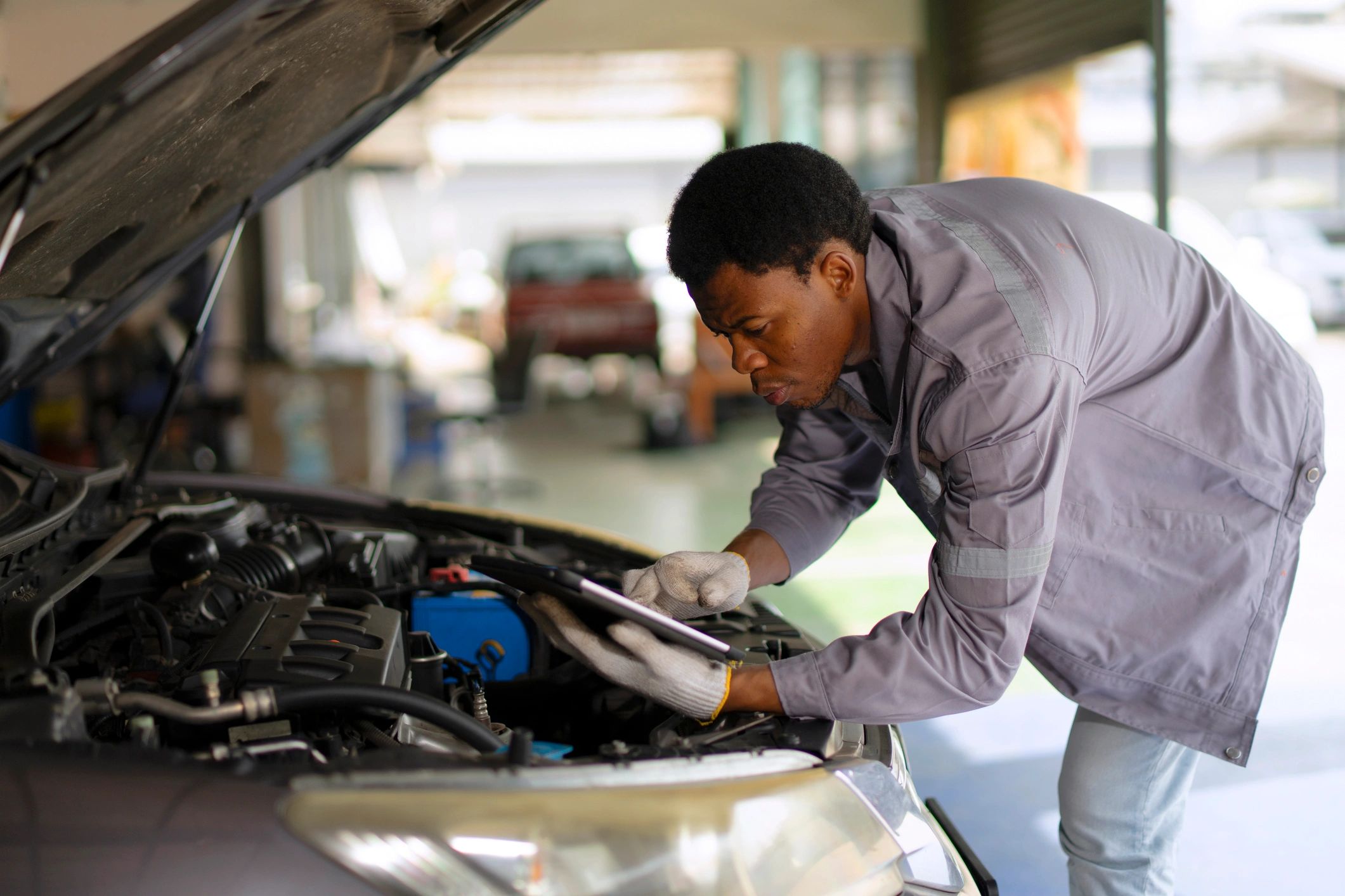 Worker inspecting a vehicle in a service workshop